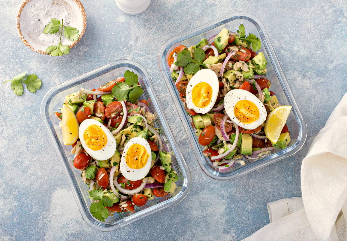 two tupperwares of tuna, veggies, and eggs