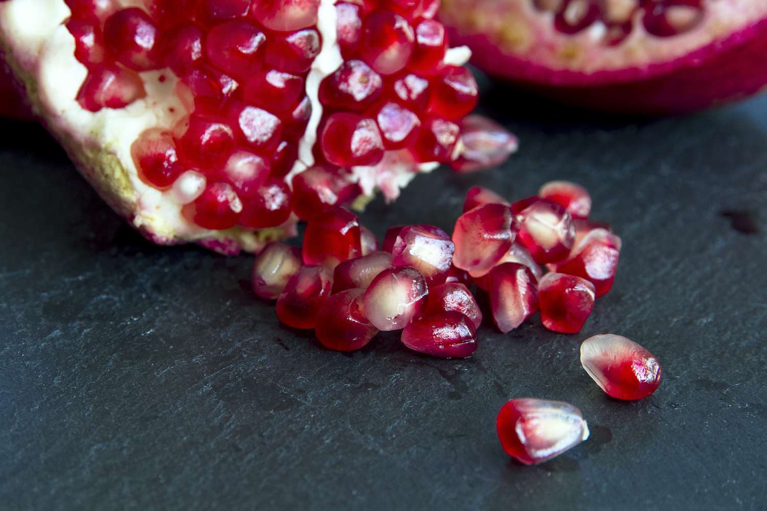 Pomegranate seeds on slate