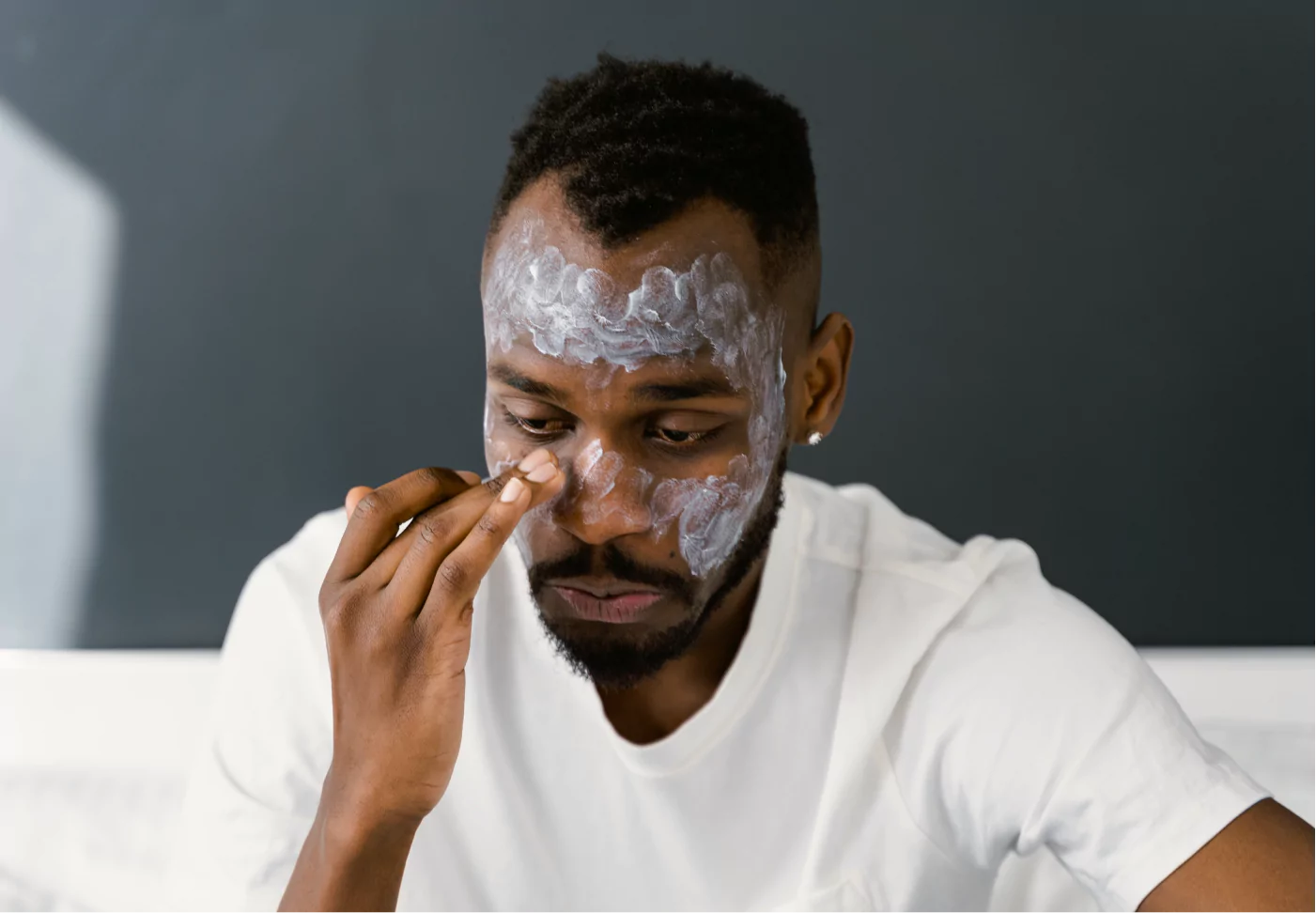 a man putting lotion on his face